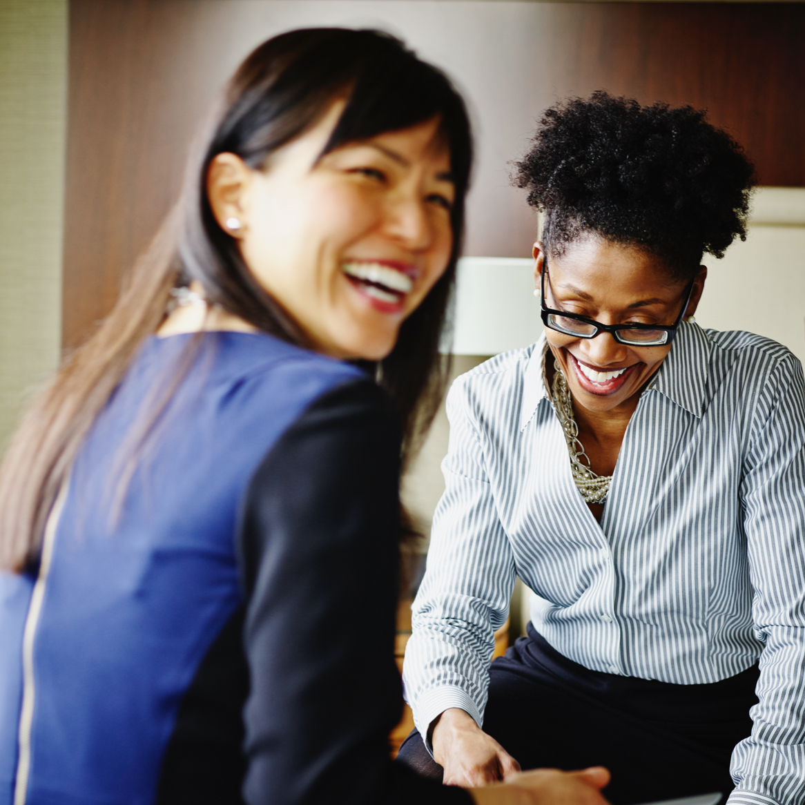 Discover Who You Can Become at Berkley A group of career women smiling and working in a hotel suite.