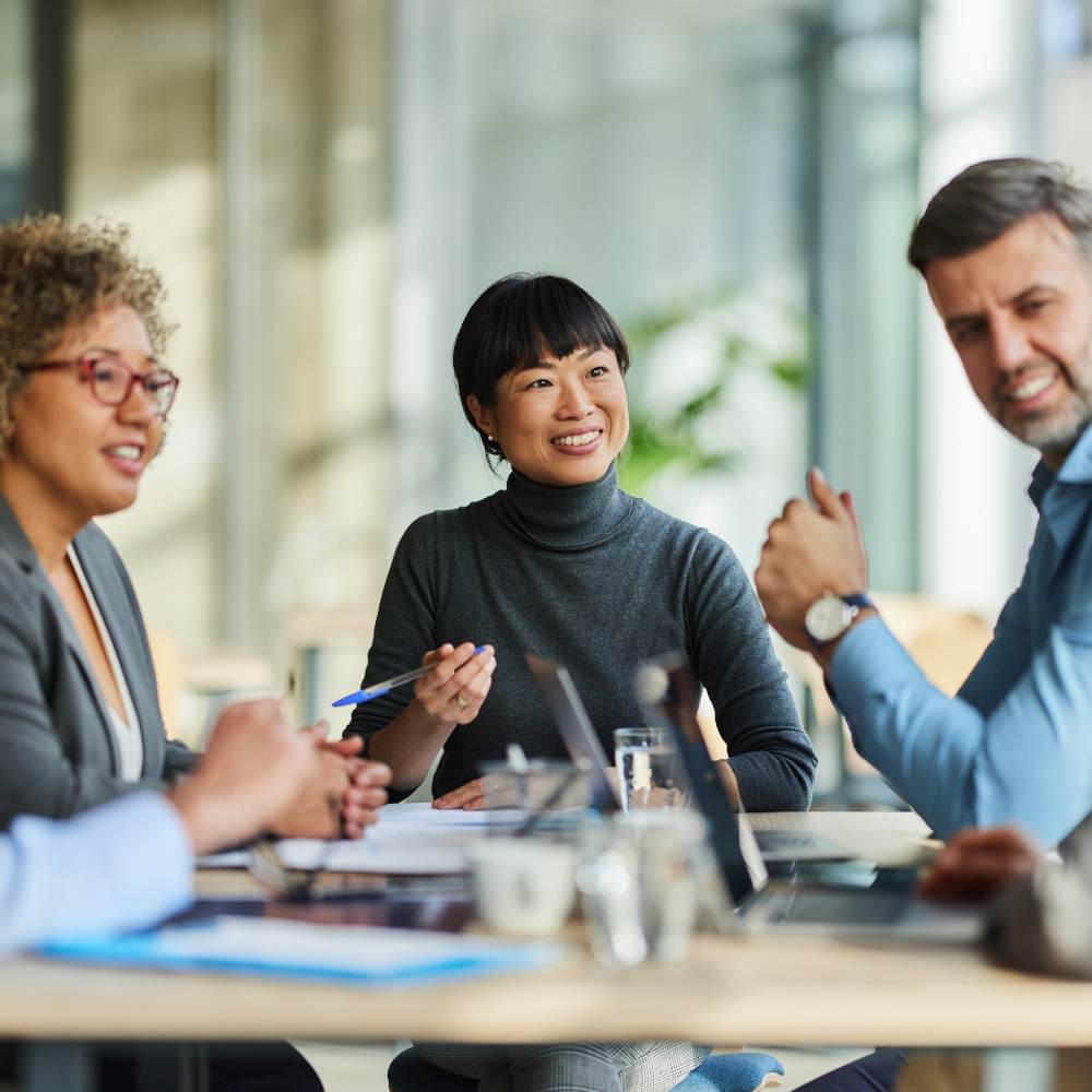 4 people smile while taking at a table
