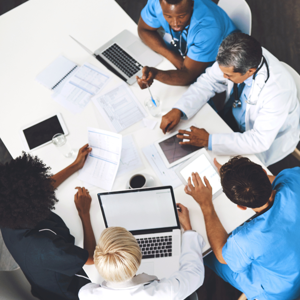 Five doctors talk around a table