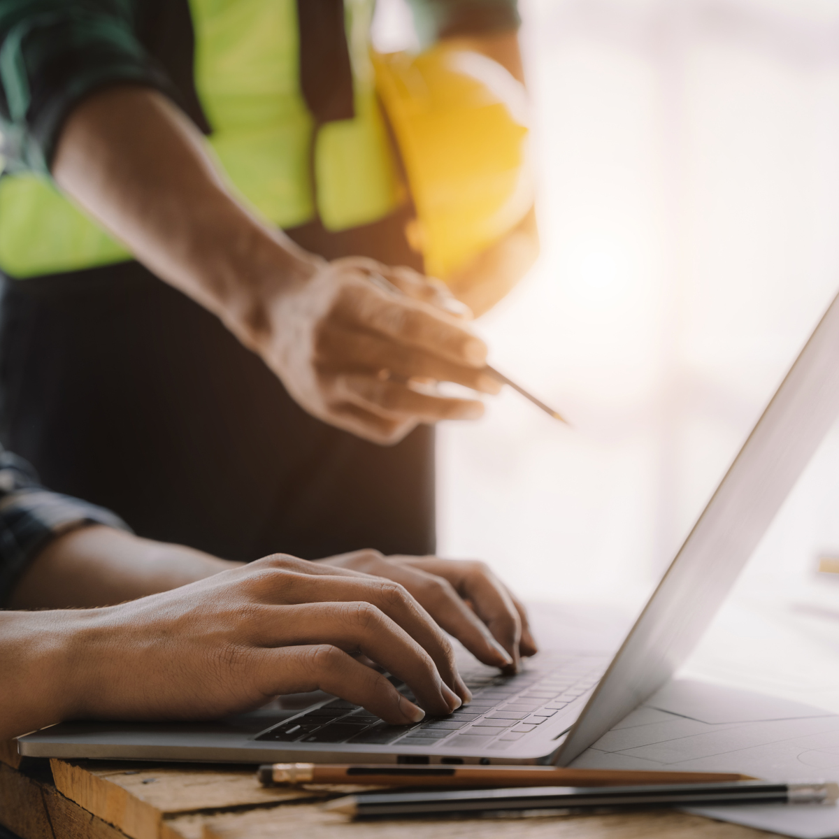 Two workers view laptop