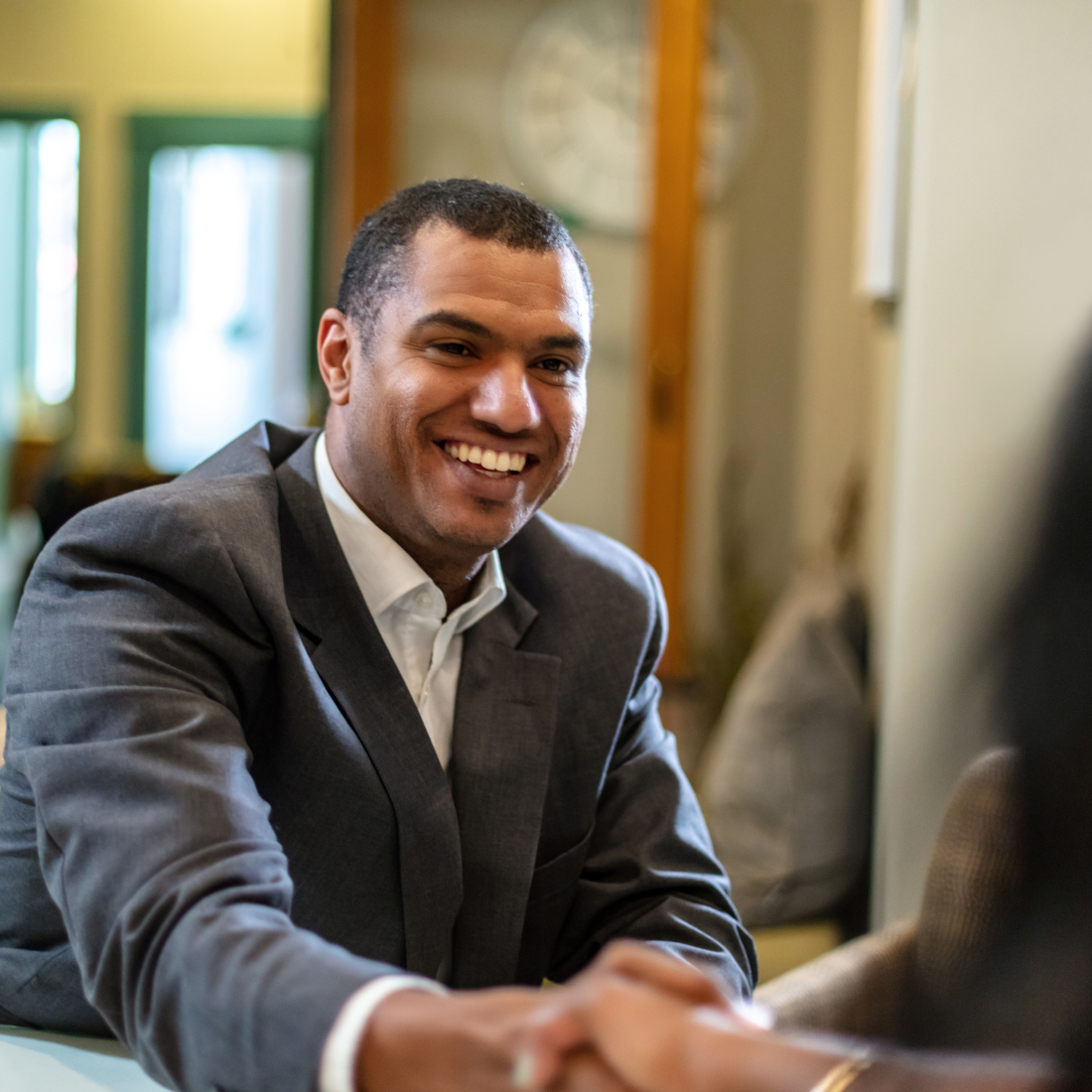 Man smiles while shaking hands