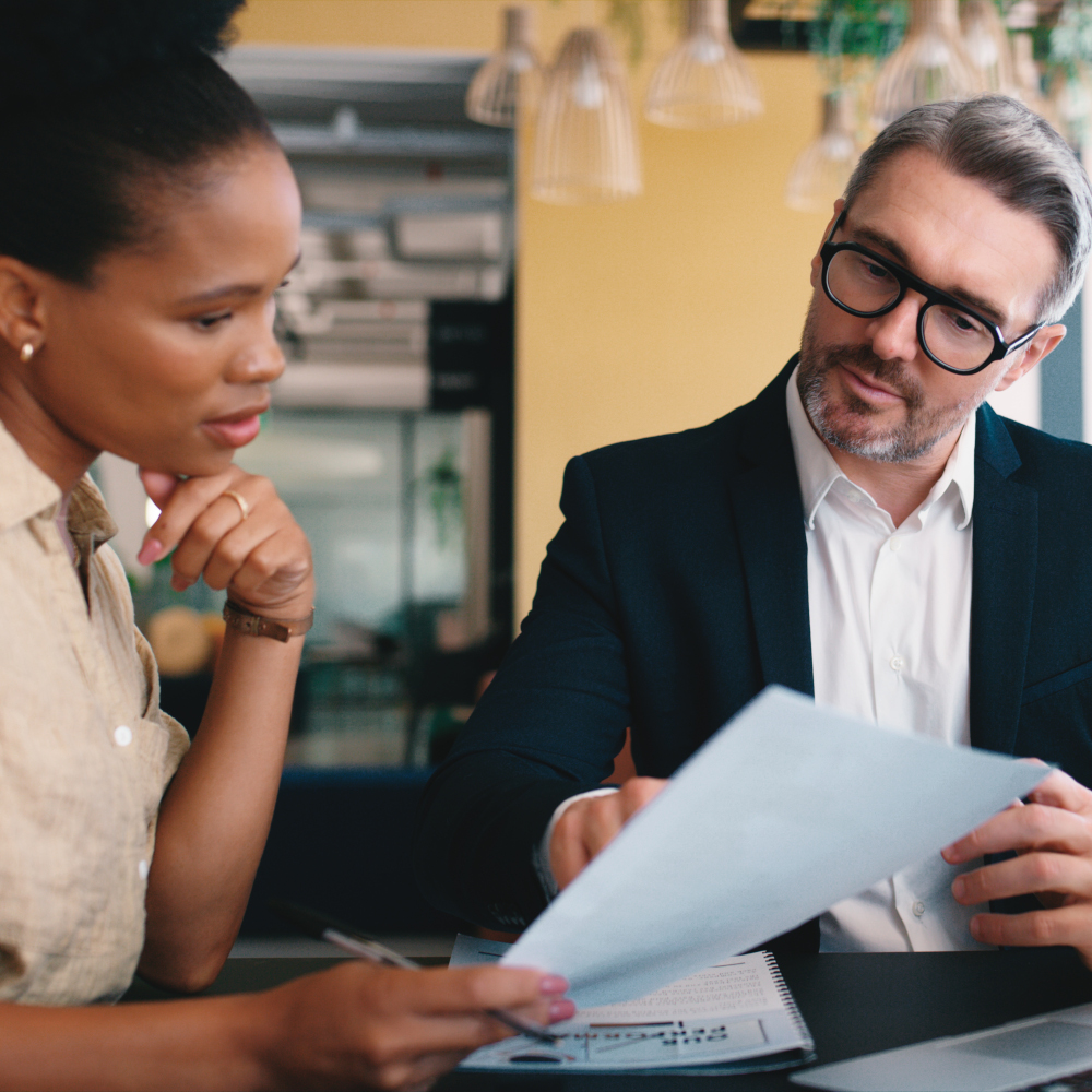 Woman holds paper while man points at it