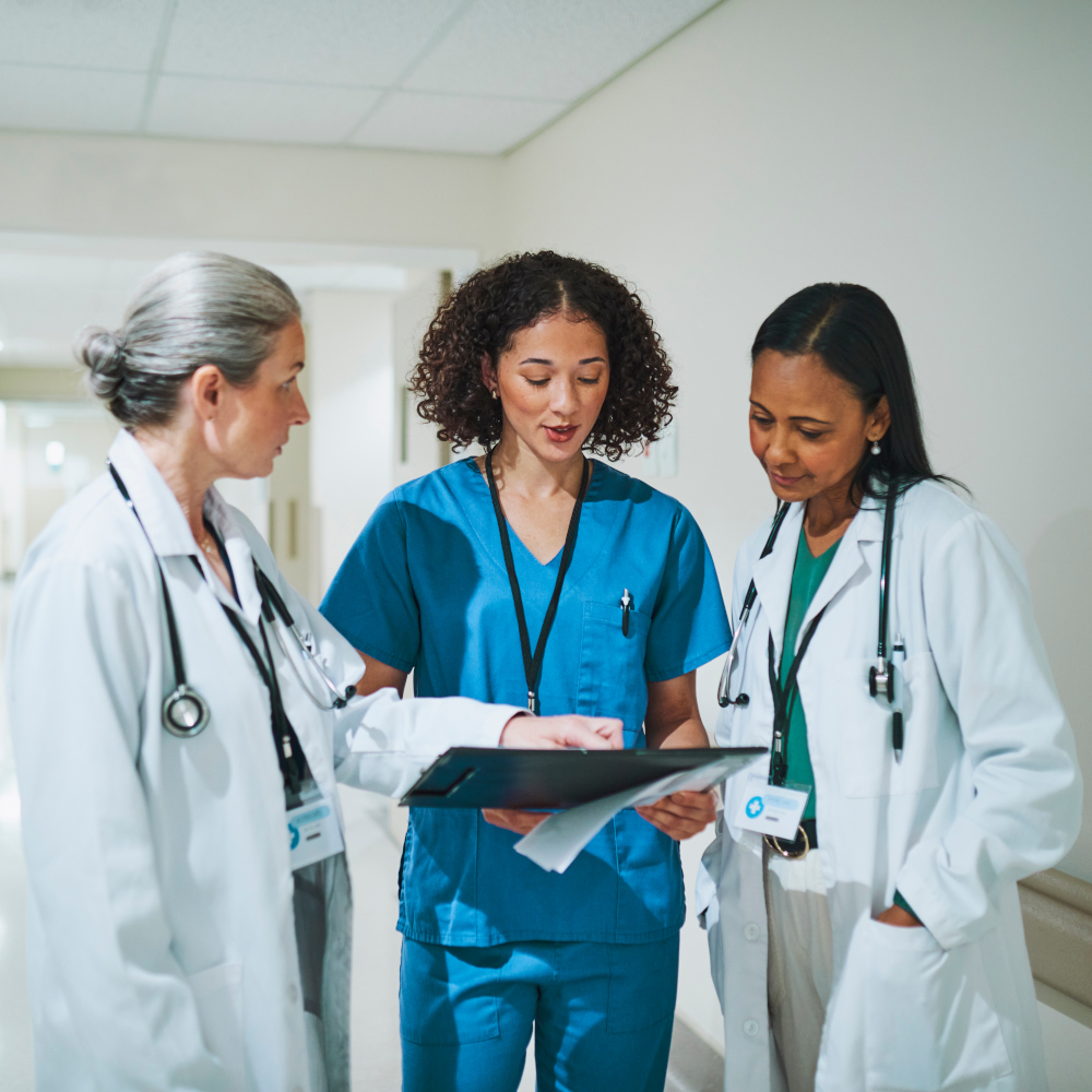 Three doctors talk in hallway