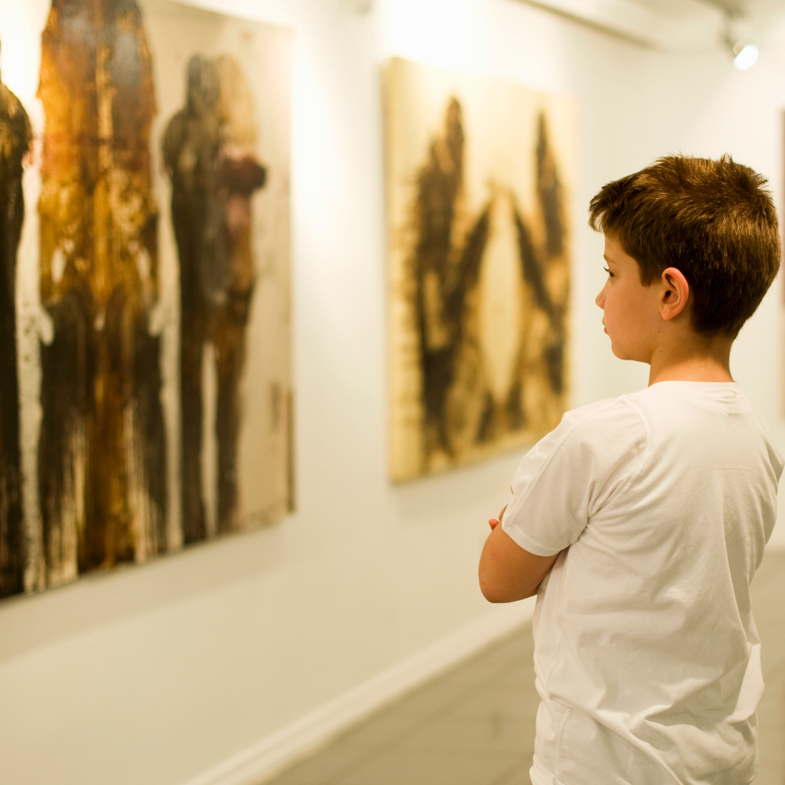 Boy looks at paintings