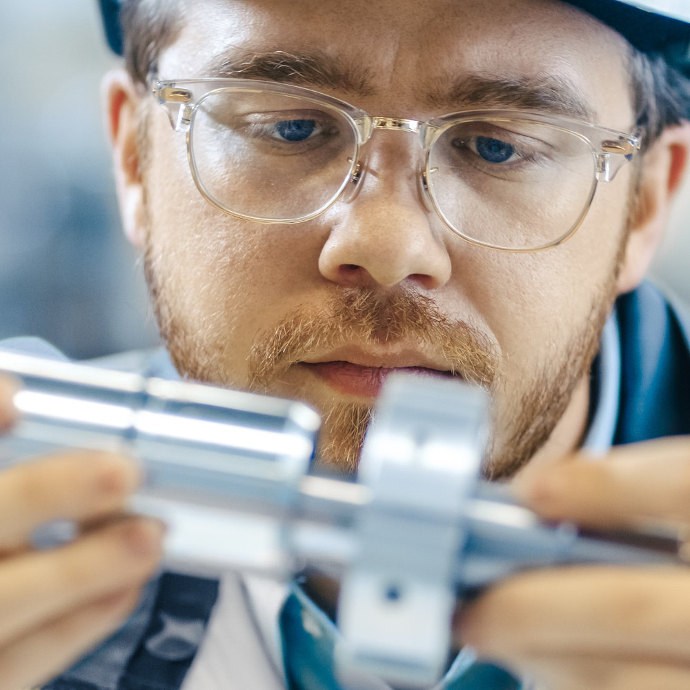 Worker looks closely at machine part