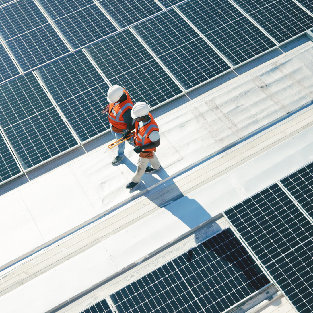 2 workers check solar panels